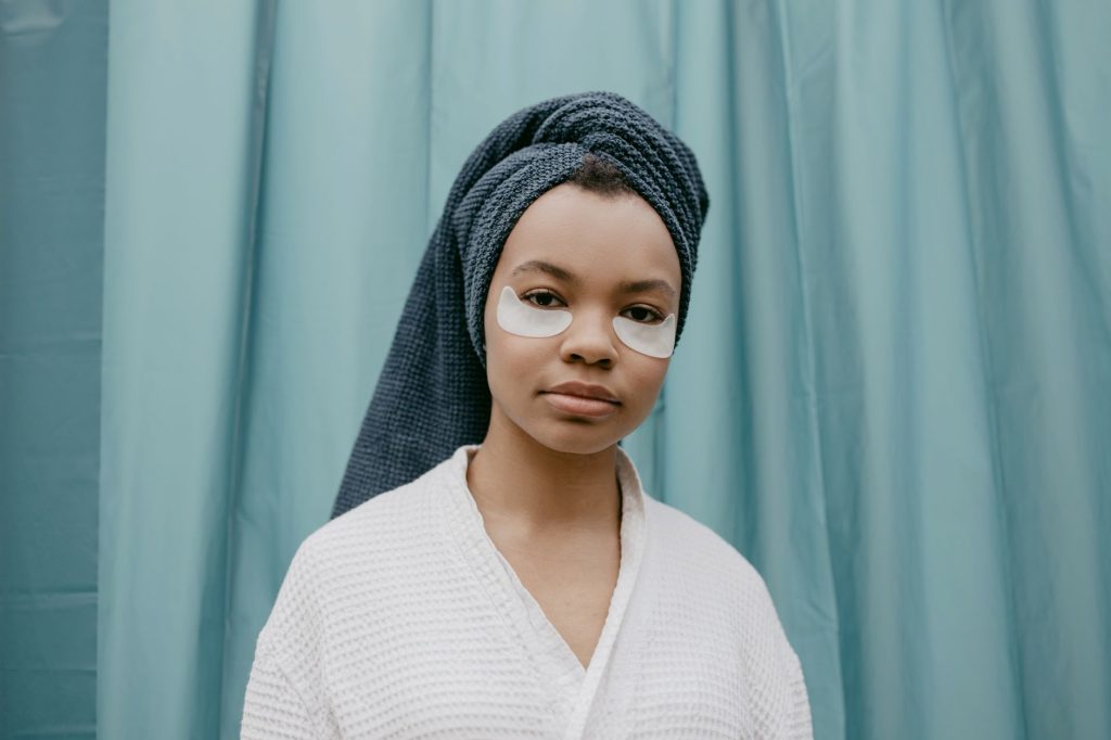 A woman in a white robe wearing under-eye patches